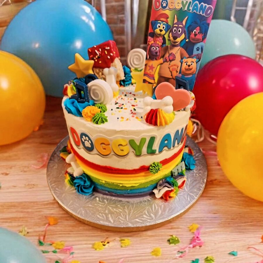 Rainbow Doggyland birthday cake with character topper and piped swirls