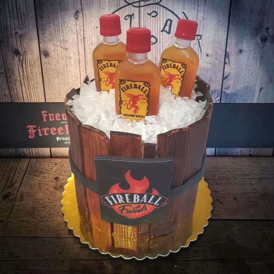 Wood barrel cake with Fireball bottles on ice