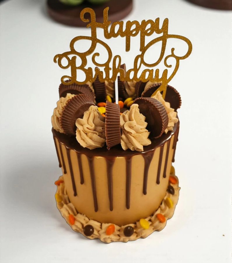 Chocolate drip birthday cake topped with peanut butter cups
