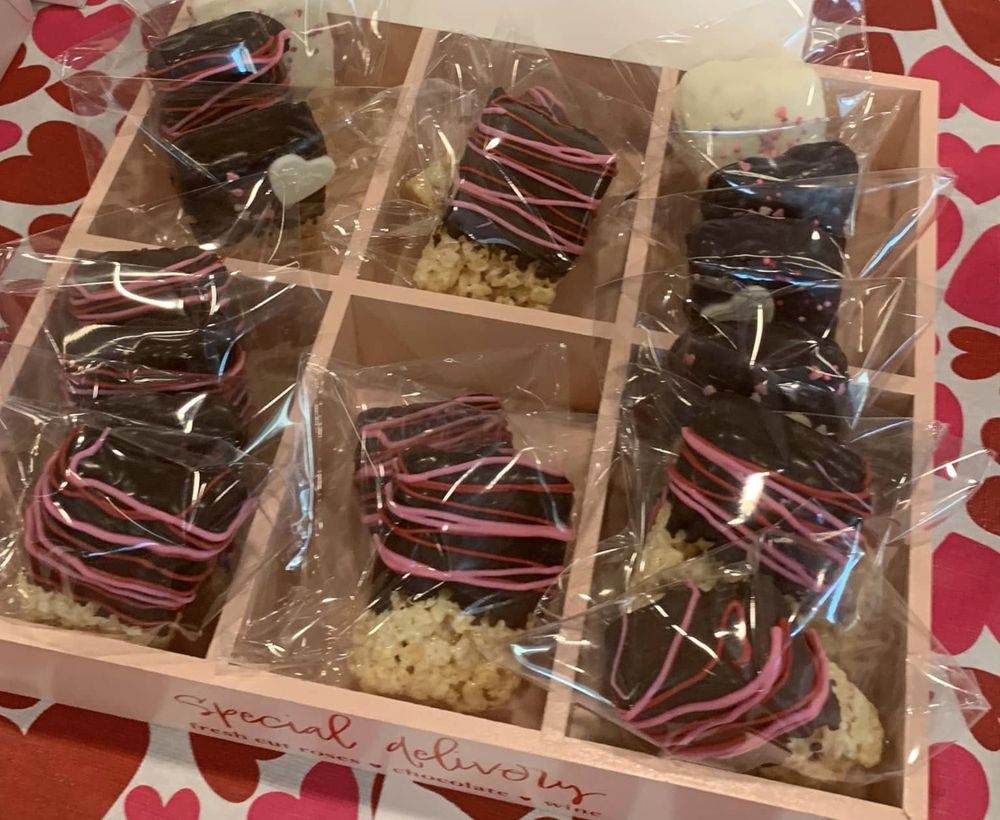 Valentine Rice Krispie treats dipped in chocolate with pink and red drizzle, individually wrapped